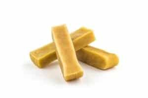 Three sticks of beeswax lying on a white background.